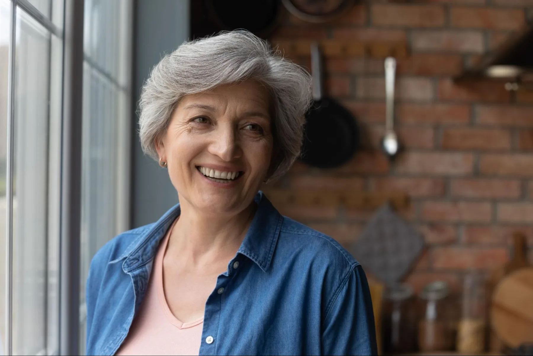 Elderly woman wearing newly fitted dentures and smiling